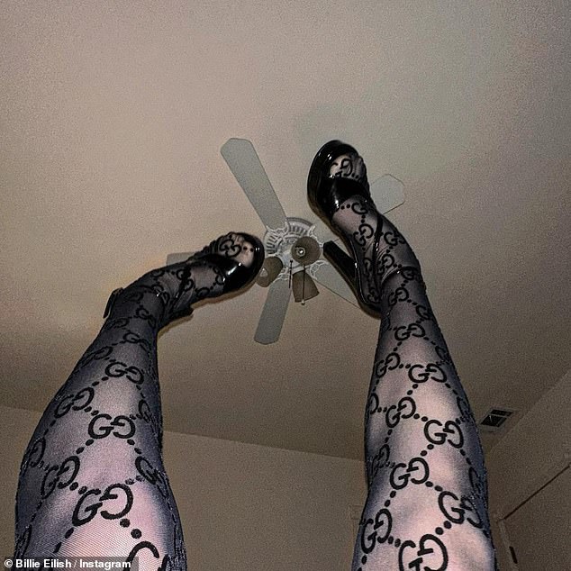 Kicking: In another photo, she kicked her legs up to the ceiling with her legs covered in sheer black stockings.