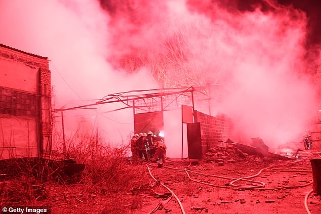 Firefighters work to put out a blaze at a fireworks storage facility after it was struck by a Russian missile in Kharkiv yesterday