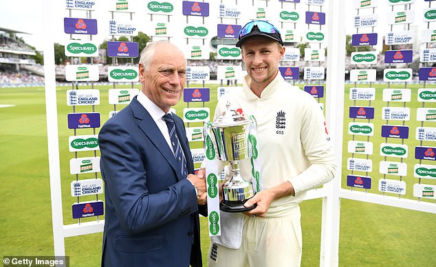 Graves presents England captain Joe Root with a trophy after a Test match win in 2019