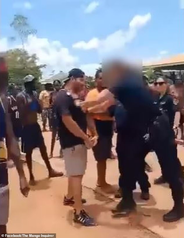 The male police officer is caught on camera verbally arguing with a man during the commotion before pushing him away.