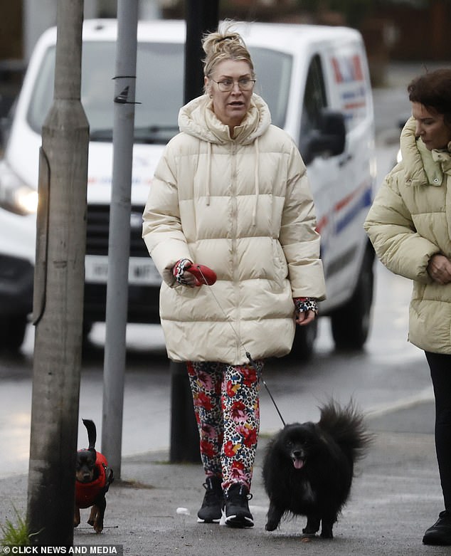 Casual attire: Sporting a cream puffer coat and floral cheetah print tracksuit, Jo's signature barbed wire on her bicep was covered