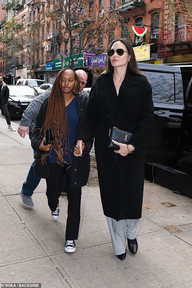 Stylish: The star, 47, looked effortlessly chic in a long black trench coat, teamed with gray pants and ankle boots