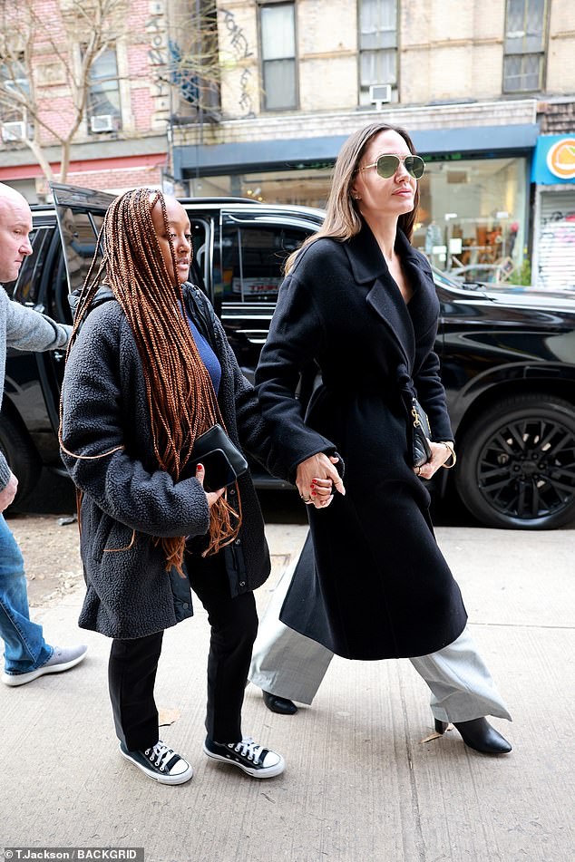 Looking good: Angelina rocked a soft and glam makeup look under a pair of chic sunglasses, while carrying a tote bag