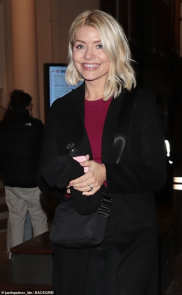 Beauty: The This Morning host, 41, bundled up in a long black coat which she teamed with a fuchsia sweater for the outing