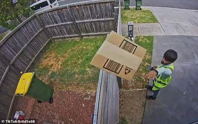 After several seconds of indecision, the courier makes a split-second decision to send the box containing an unknown object flying over a high wooden fence.