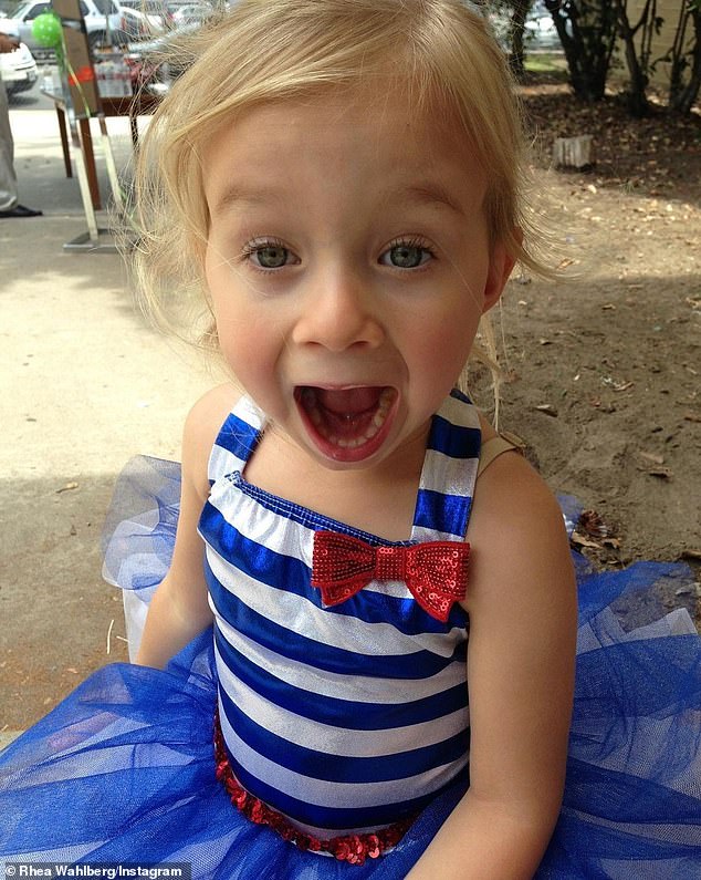 Like a princess: The girl showed her fun and playful side by opening her mouth wide while wearing a blue and white tutu dress.