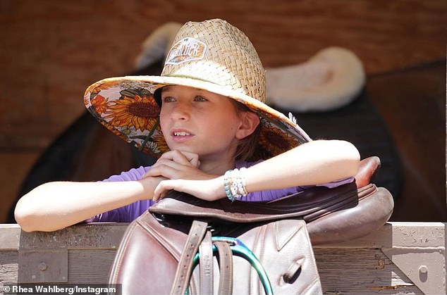 Horse Lover: Grace also appears at a horse stall wearing a large straw hat.