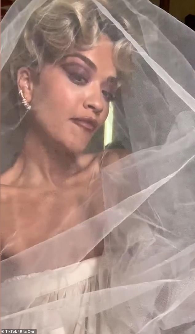 Here comes the bride!  The singer, who will release her new single You Only Love Me on January 27, wore the glamorous white ruffled dress and matching veil in the hilarious video.