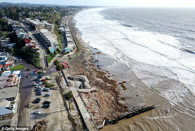 In an aerial view, debris from the storm lies along the beach near a sand-covered parking lot on January 10, 2022 in Aptos, California.