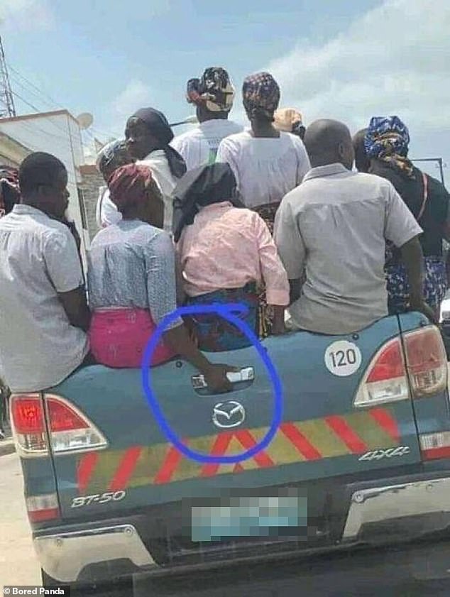 Hold on tight!  This group in Mozambique will be shocked if they have to break up quickly: a woman clings to a door handle for support.