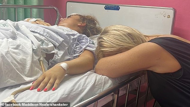 Maddi's family have managed to raise £75,000 to bring her back to the UK with a specialist team after they discovered her travel insurance did not cover the cost of transporting her home. Pictured: Maddi's mother Karen lying next to her daughter in hospital