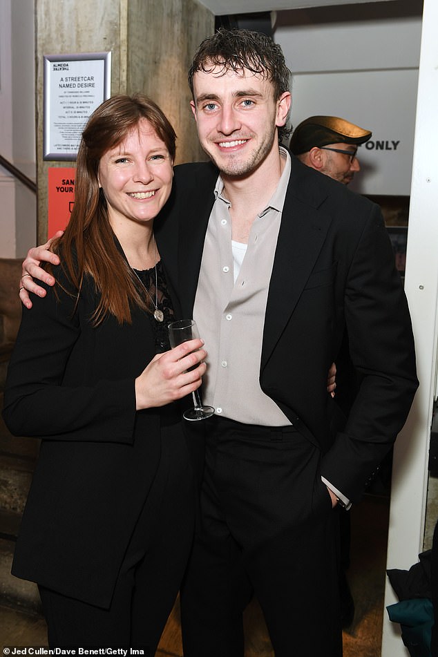 Smiles: Paul also stopped for a photo with director Rebecca Frecknall, who kept up the netural theme in a black suit.