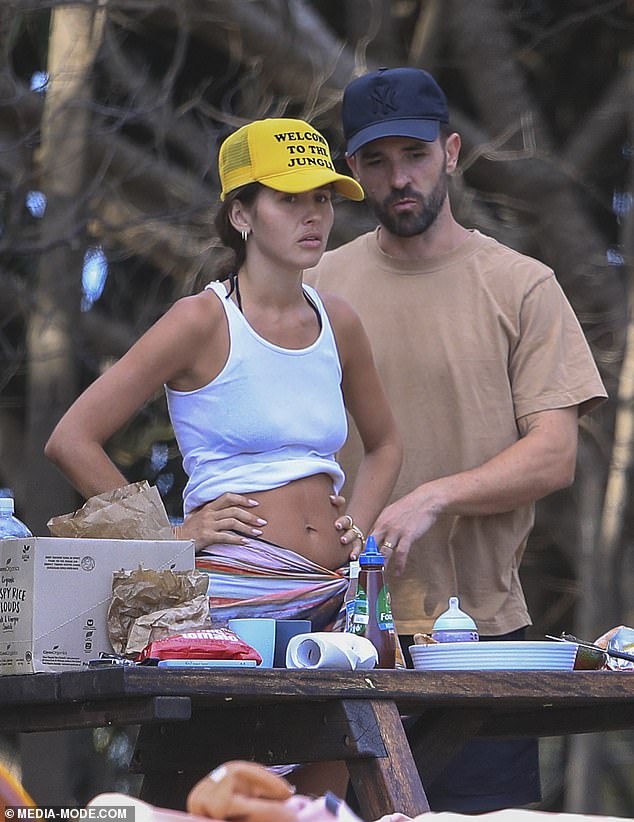 Shannon donned a brown T-shirt over her black bathing suits and donned a black cap as she helped unpack the condiments.