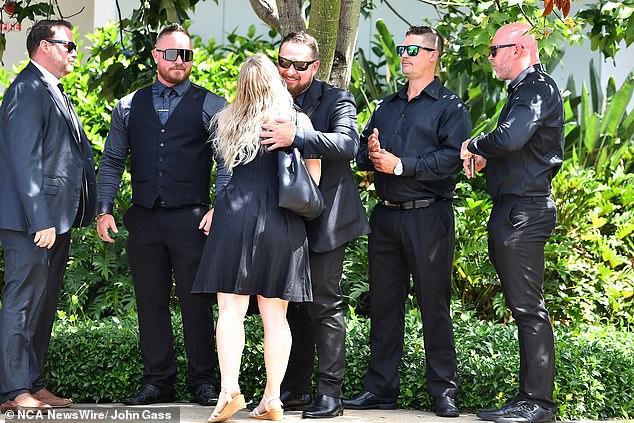 Mourners embrace as they arrive for Mr Jenkinson's funeral on Friday.