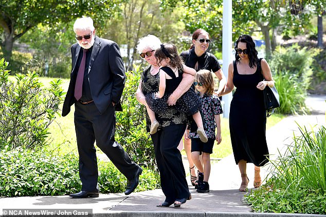 A group of Mr. Jenkinson's loved ones walk with two children to the pilot's funeral.
