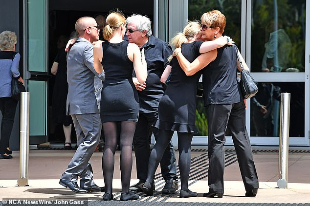 Three women and two men embraced when they met outside the church.