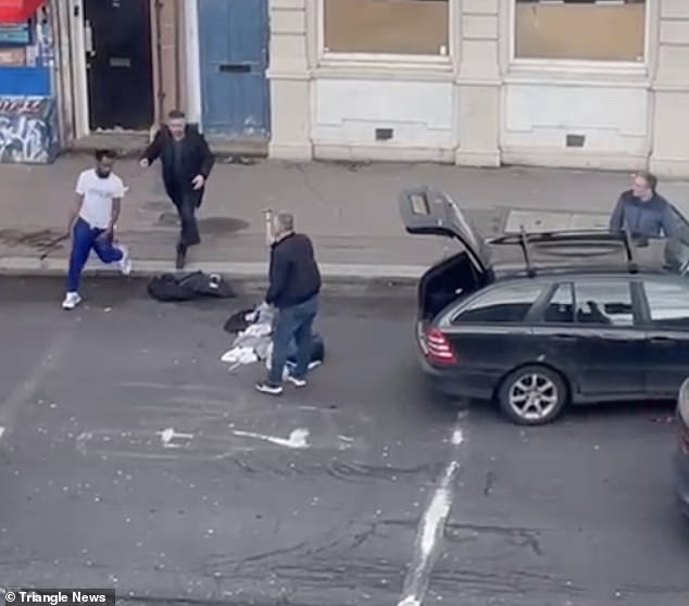 Another man, apparently a friend of the pedestrian, joins in.  As he does so, the driver appears to take a hammer out of the trunk of his car.