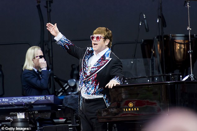 In his tuxedo decorated with a dazzling pattern of red, blue and white flames on the cuffs and lapels, Elton looked like a rock veteran in the outrageous outfit (pictured).