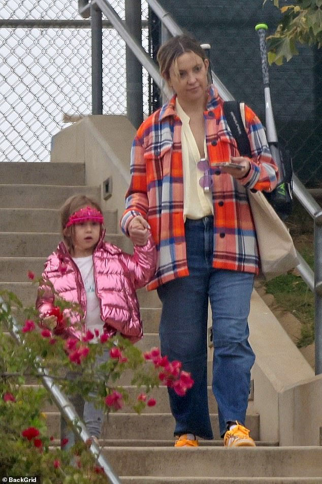 On trend: The 43-year-old silver screen siren looked stylishly bright in an oversized orange and blue plaid jacket and flared jeans