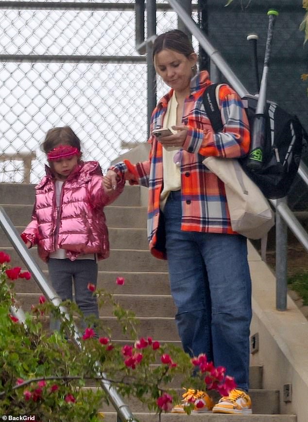 Miniature Style: The petite actress from The Glass Onion: A Knives Out Mystery wore a metallic pink jacket while holding her mother's hand.