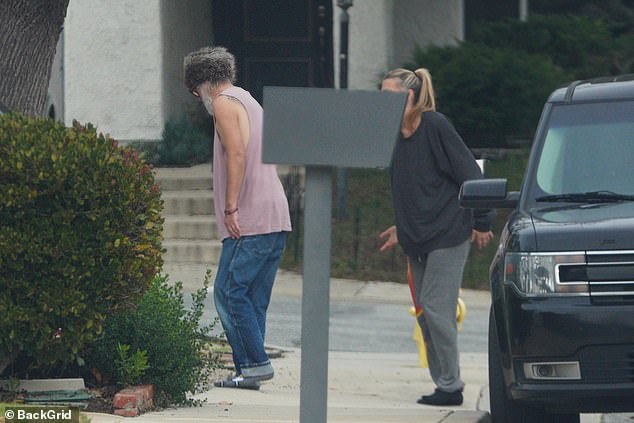 He was seen outside the Los Angeles home he shares with his new wife, Beauty Beach Lounge stylist Stephanie Hobgood, dressed in a pink tank top, jeans and a fur hat.