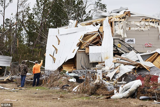 Locals inspect the remains of residences that have been reduced to piles of rubble in Pratville