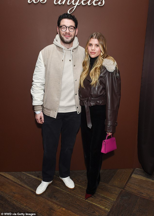 Couple: Sofia Richie reached out to her fiancé Elliot Grainge as they enjoyed a night out at celebrity hotspot Delilah on Wednesday