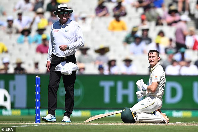 The Australian batsman can't believe it as he watches the replay on the big screen confirming that he was short of wicket.