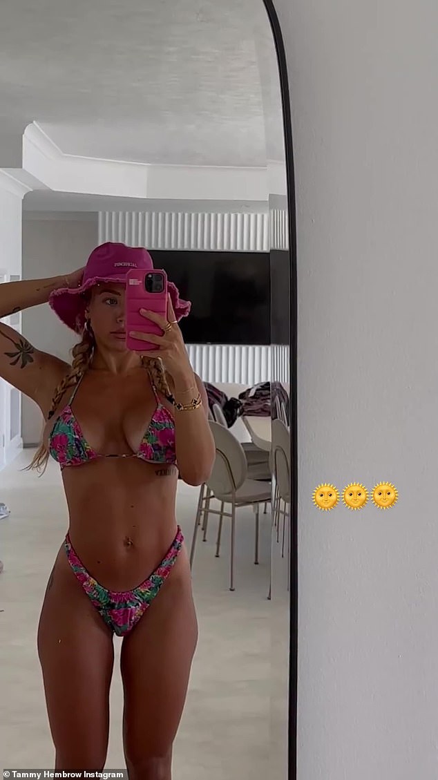 The 28-year-old fitness influencer pulled her hair up into two ponytails and opted for a bright pink denim floppy hat.