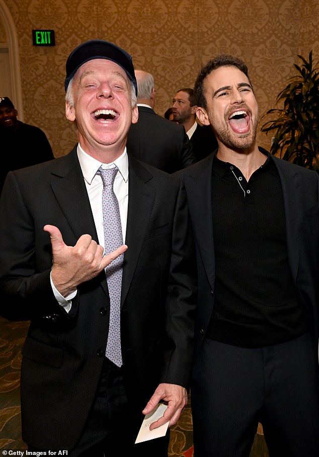 Creator: James also took a photo with Mike White, the creator of the show, who was wearing a black suit with a silver tie and a black cap with a white sign printed on the hat.