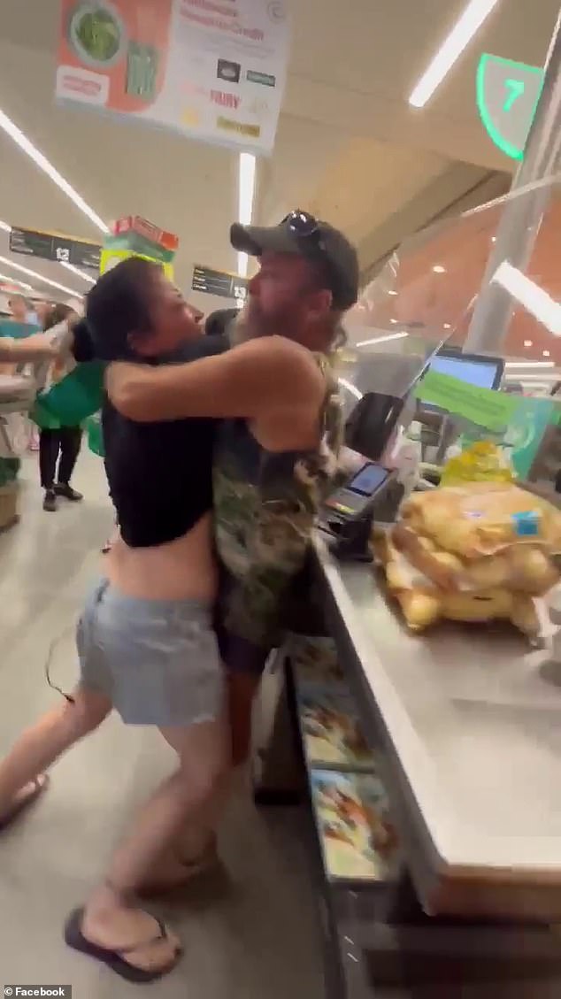 A member of the public finally steps in and pins the woman in a tight bear hug.