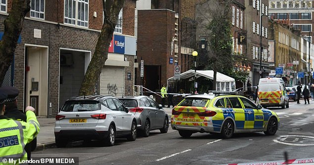 Police are shown at the scene of a shooting outside a funeral in Phoenix Road, next to Euston train station.