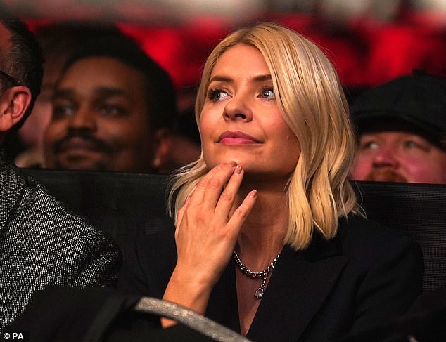 Focused: Holly watched intently as she sat front row to watch the celebrity packed fight.