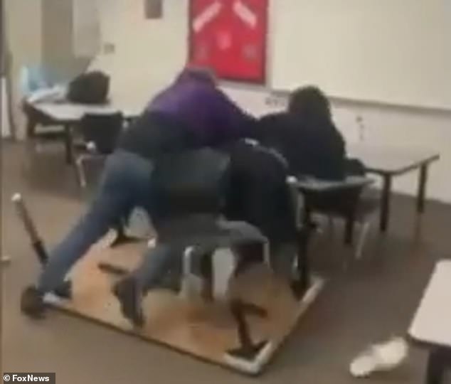 The shocking clip showed the teacher in a purple sweatshirt struggling with the student dressed in black.