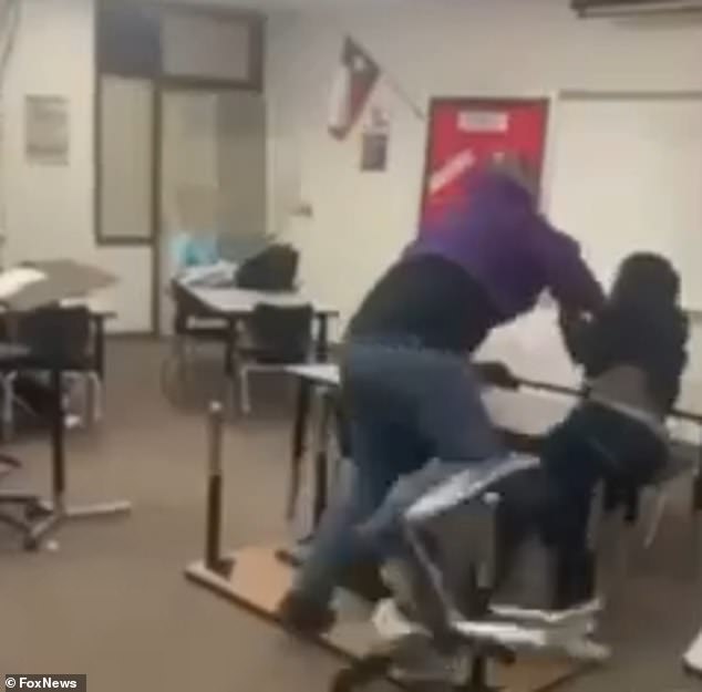 The student appeared to be running away from the teacher, who grabbed his arm as the pair fell onto a table and sent chairs flying in the classroom scrum.