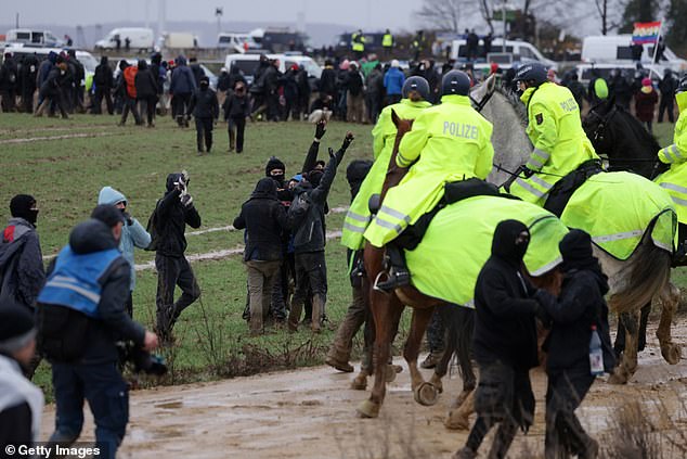 Policemen on horseback advance towards protesters outside the mine on Saturday, January 14.