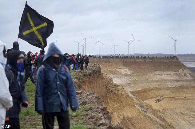 The protesters stand at the edge of the open pit mine, looking tens of meters to where the lignite was extracted.