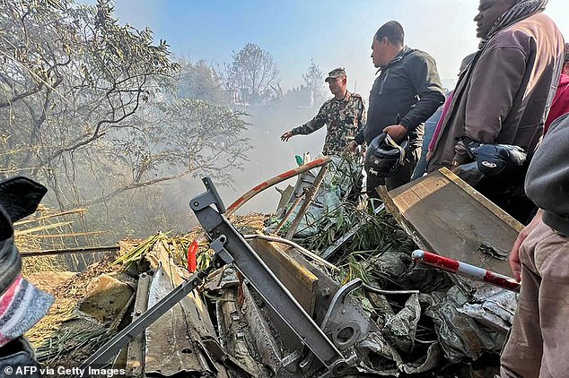 Rescuers gather today at the plane crash site in Pokhara