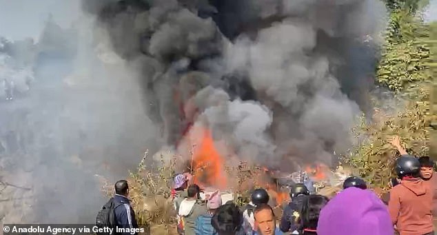 Hundreds of onlookers flocked to the crash site, where the wreckage of the plane was engulfed in flames.