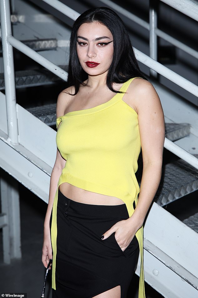 Fashion: Charli slid into a quirky yellow top that she paired with a thigh-high split black skirt