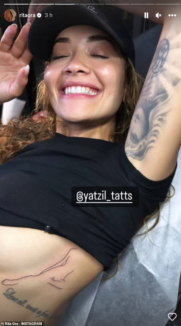 Showing off: The singer, 32, teased out her lower chest as she pushed up her top to show off the last ink on her midsection