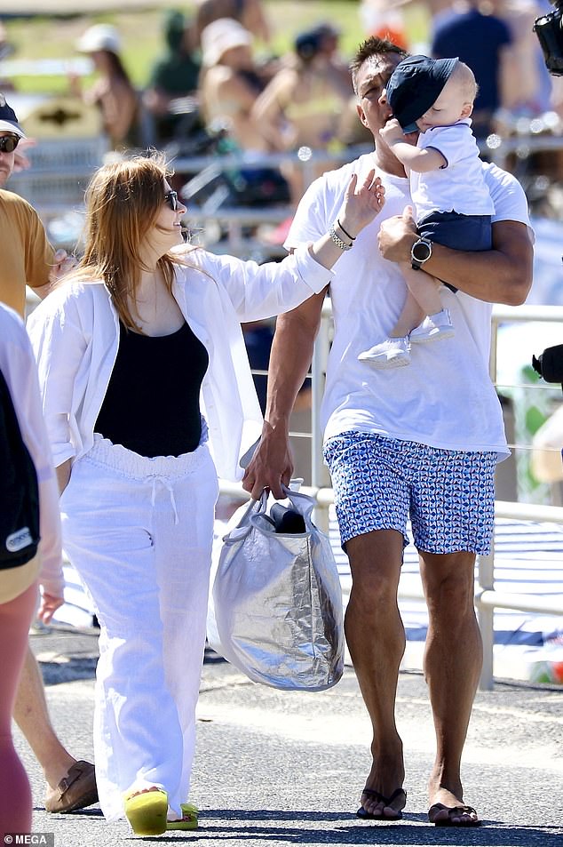 The couple smiled as they strolled through the popular beachside destination.