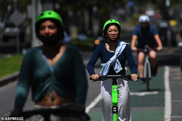 People are seen riding Lime electric assist scooters in Melbourne in 2022. More than 400 people attended emergency departments in Victorian hospitals after the scooters crashed.