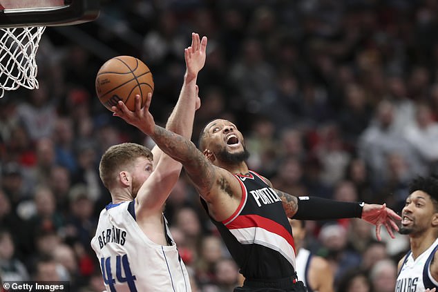 Damian Lillard of the Trail Blazers shoots a shot against Davis Bertans of the Mavericks