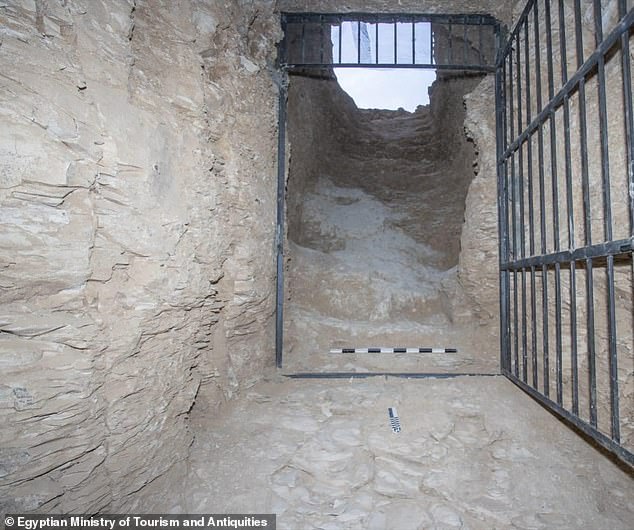 Photo shows inside the entrance of the tomb looking out. The tomb has been secured with a metal gate to prevent looting