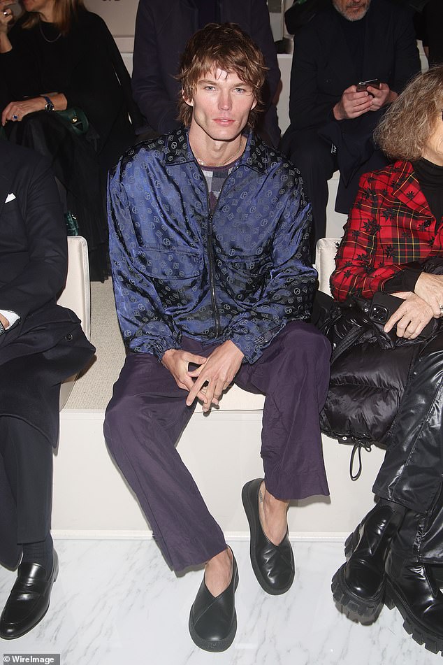 Stylish: She donned a navy silk bomber jacket and accessorized with a silver chain necklace and black loafers.