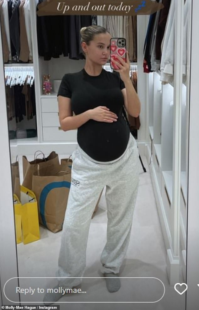 Mom-to-be: Elsewhere, Molly-Mae placed a hand on her burgeoning baby bump as she posed in a black T-shirt and gray pants for a selfie shared to her Instagram Stories