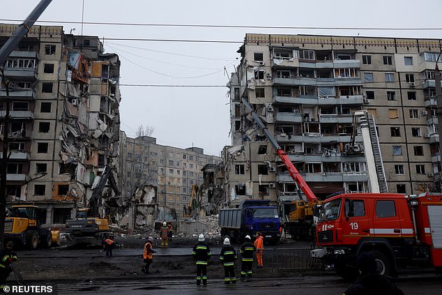 Emergency services work at the site where an apartment block was badly damaged in Dnipro