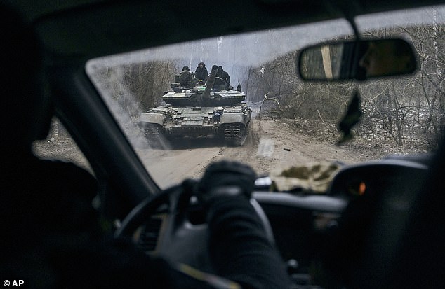 A Ukrainian tank with soldiers is seen through a car window near the front line near Kremenna in Lugansk region, Ukraine on Sunday.