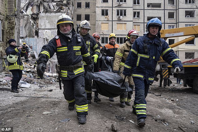 Rescue teams carry the body of a man who was killed in a Russian missile attack on an apartment building in the southeastern Ukrainian city of Dnipro on Monday.